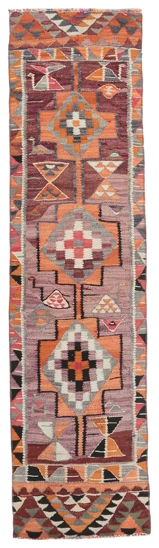 Full top view of a rust and gray geometric Anatolian runner rug on a white background