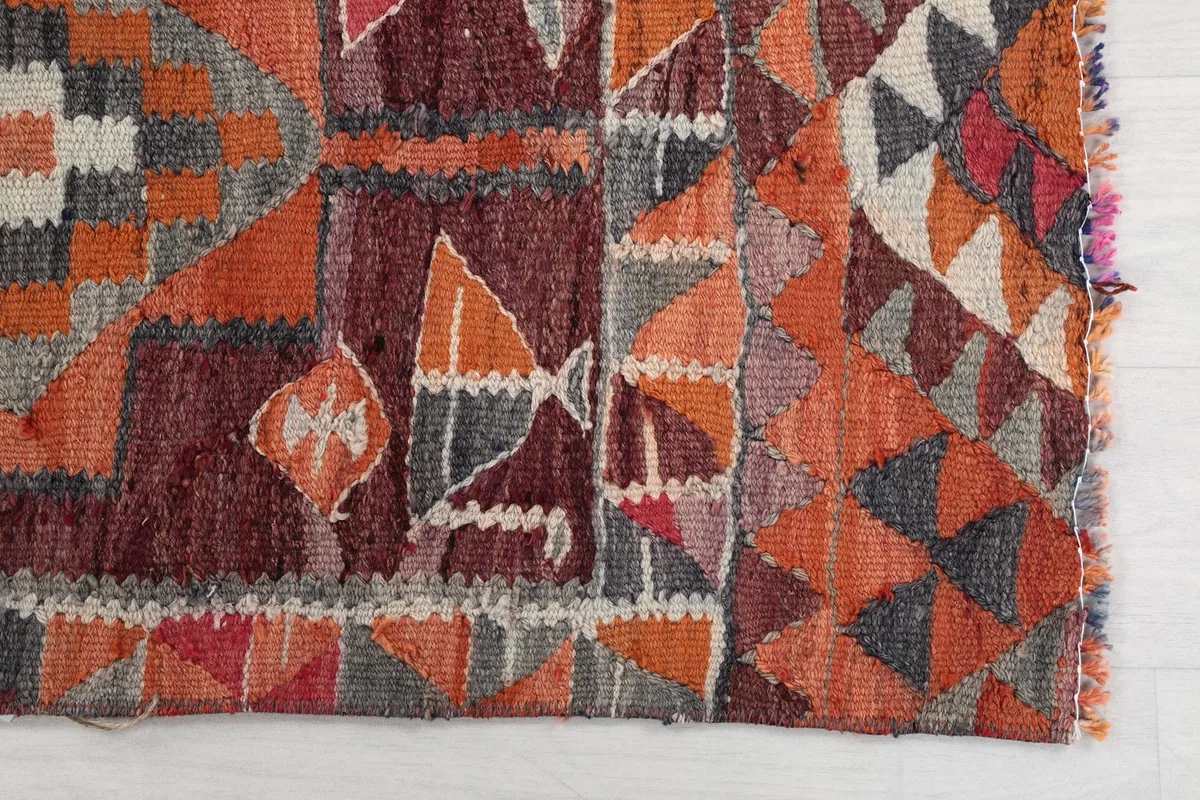 Detailed view of the complex geometric motifs and color variations within the rug's design