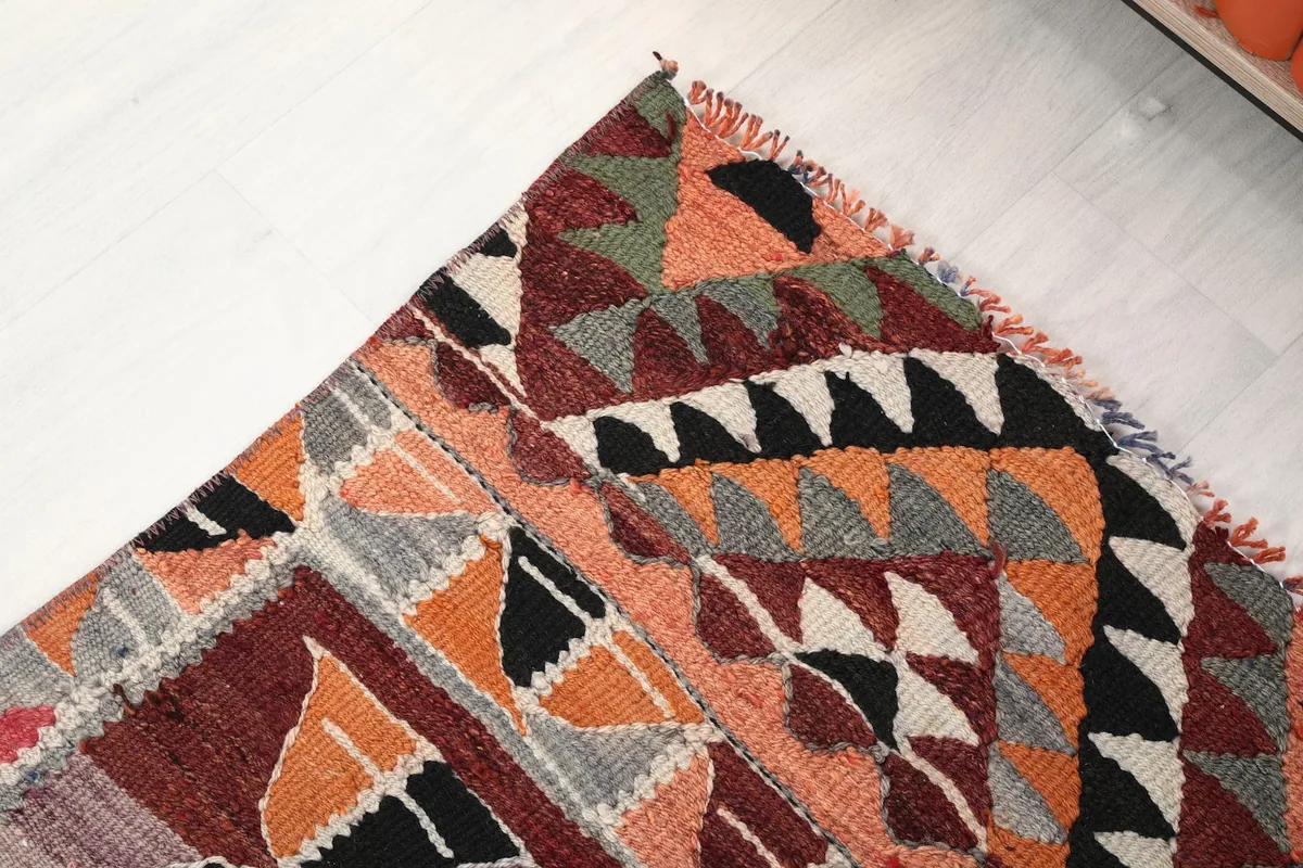 Close-up of the rug's end border, showing intricate tribal patterns and fringed edge