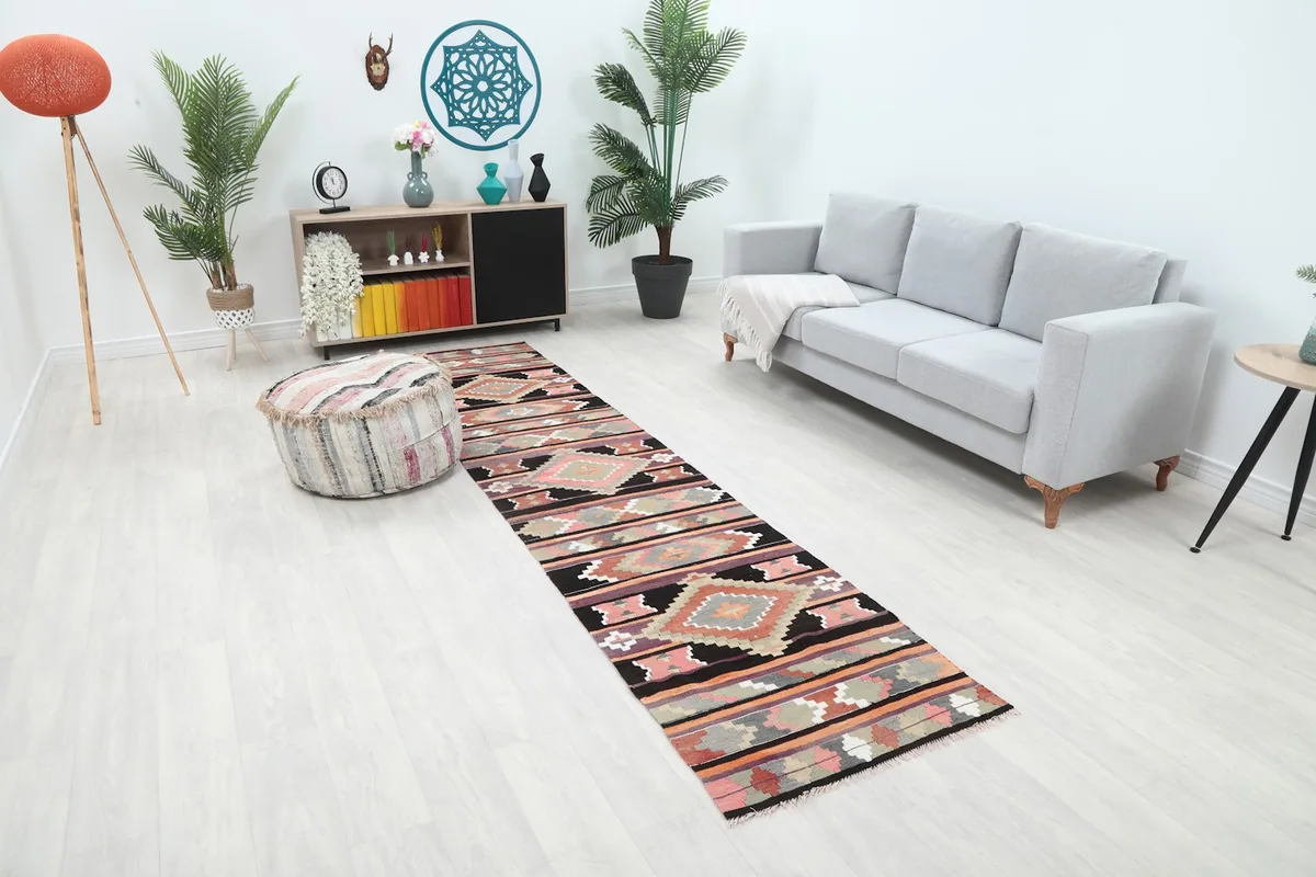 An angled view of the black, pink, and orange geometric runner rug extending down a contemporary hallway.