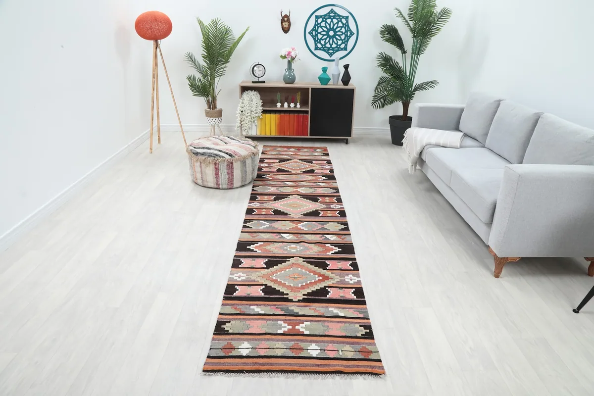 Runner rug featuring black, rust, and pink geometric patterns in a modern hallway setting