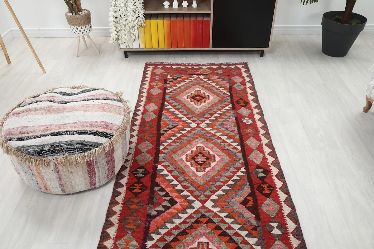 Overhead view of the red geometric runner rug in a room setting with a light-colored floor