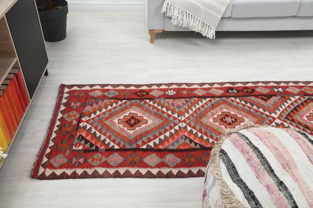 Runner rug laid out in a living area, seen from a low angle, highlighting its length