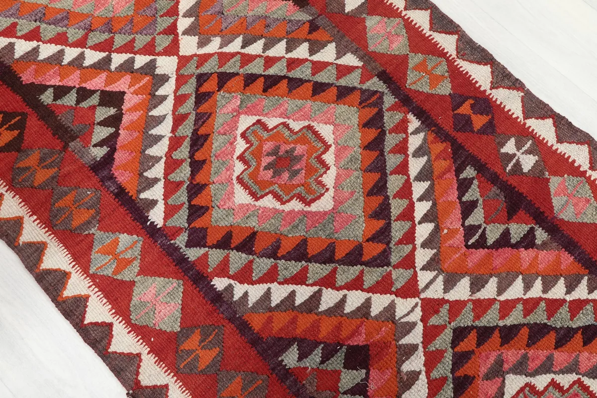 Close-up of the central geometric diamond patterns in red, orange, pink, and gray