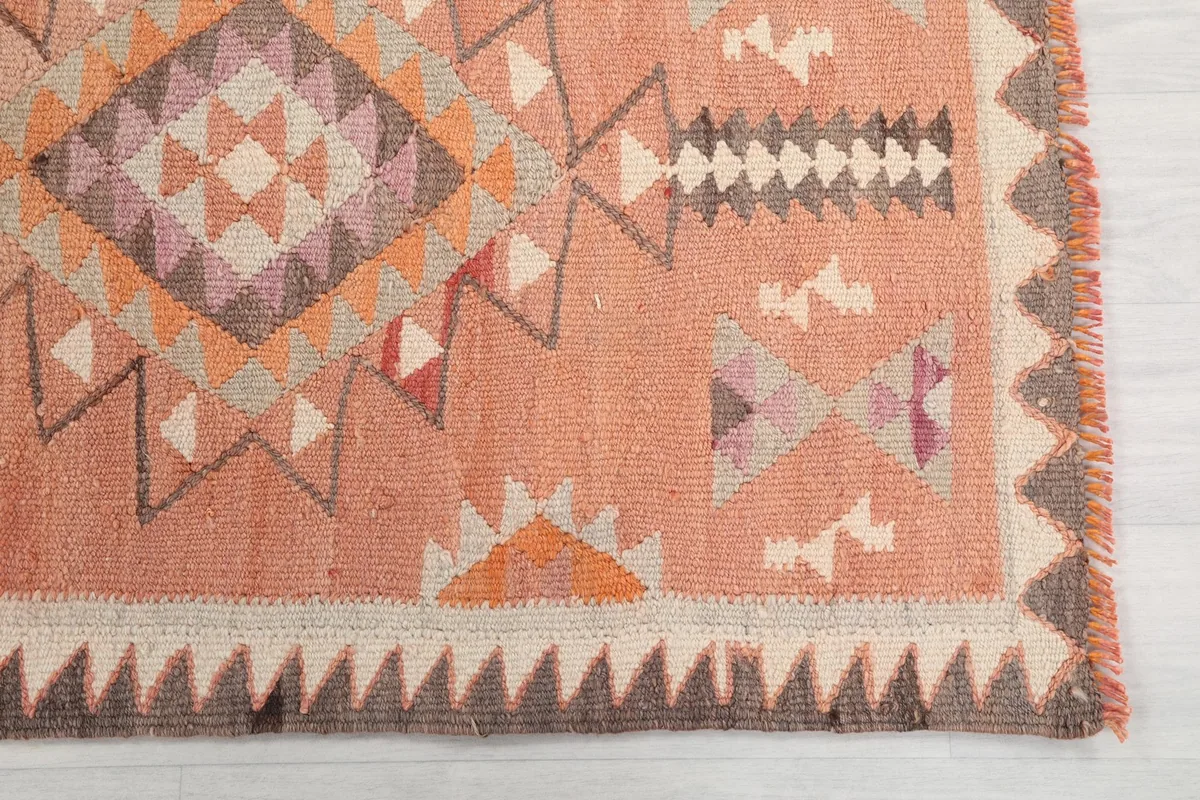 Close-up detail of the hand-knotted wool pile and geometric patterns at one end of the runner
