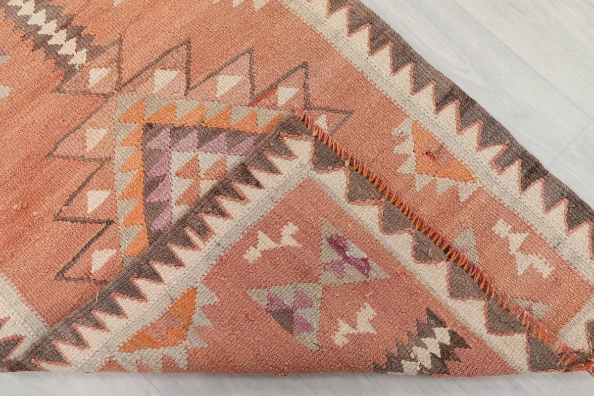 Corner of the runner folded back to show the cotton foundation and reverse side