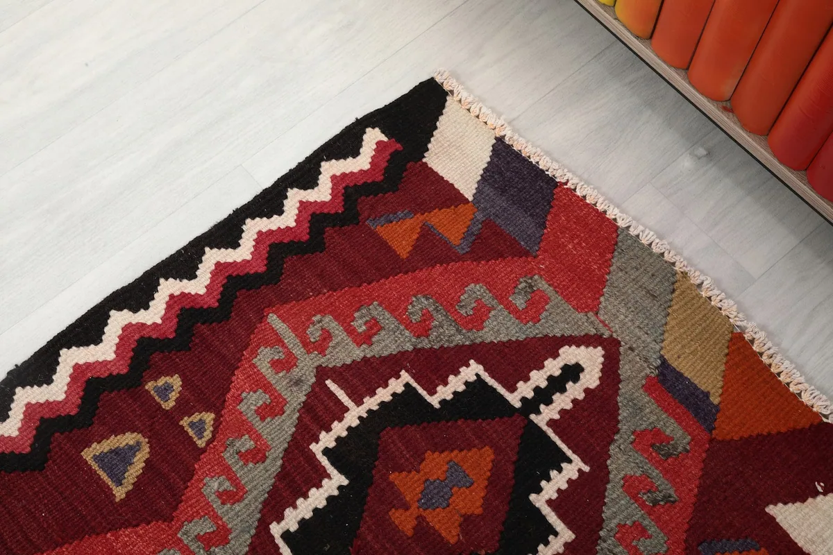 Close-up of the rug's border showing the zigzag pattern and wool texture