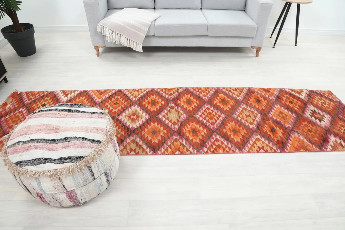 Full room view of the orange geometric runner rug in a bright, minimalist space
