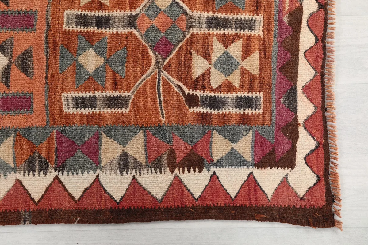 Detail of the rug's geometric border and tribal patterns