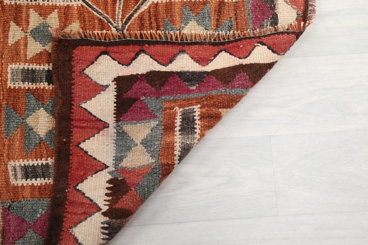 Close-up of a folded corner, revealing the rug's construction and colors