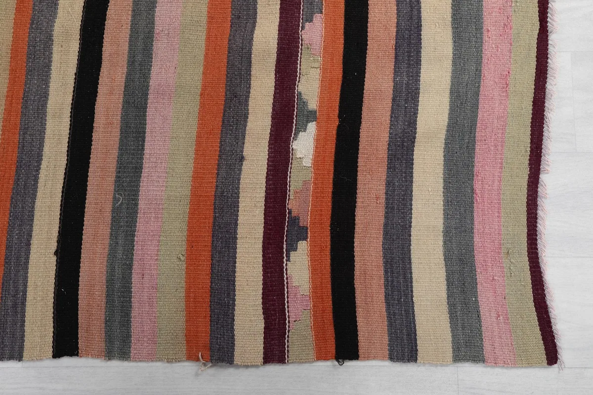 Detailed view of the rug's stripes and texture, showing variations in color and weave.