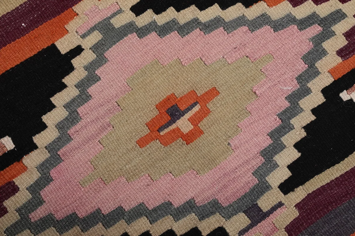 Close-up detail of the central geometric diamond motif, highlighting the pink, beige, and gray colors.