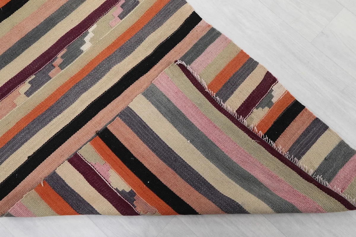 View of the rug folded back, showing the consistent striped pattern on both sides.