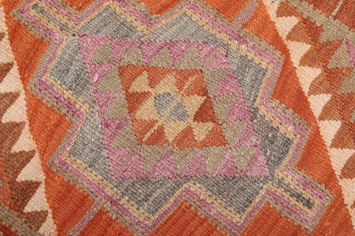 Macro view of the rug's wool pile and hand-knotted texture within a prominent geometric motif
