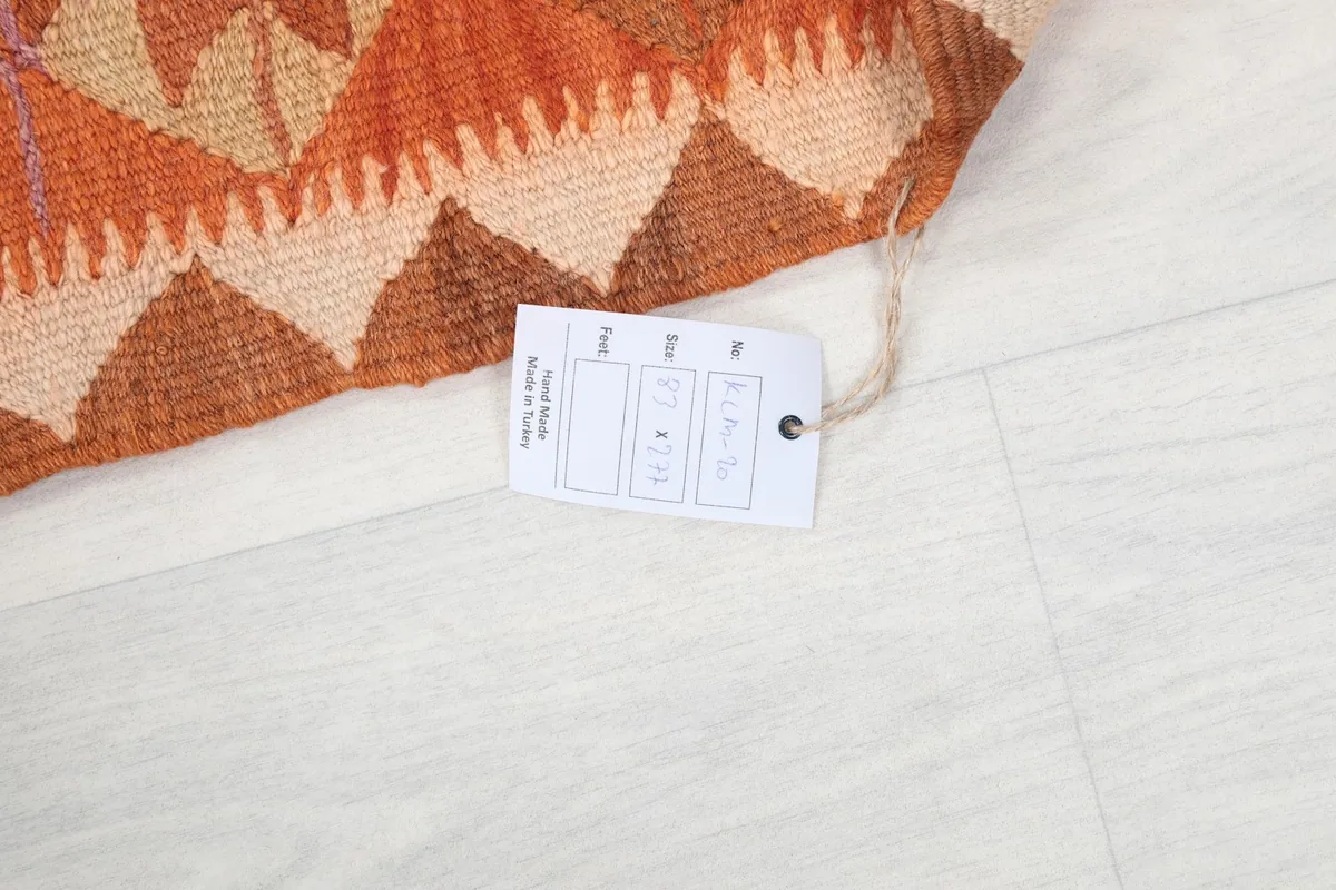 Close-up of the product tag attached to the rug, displaying its dimensions and material information