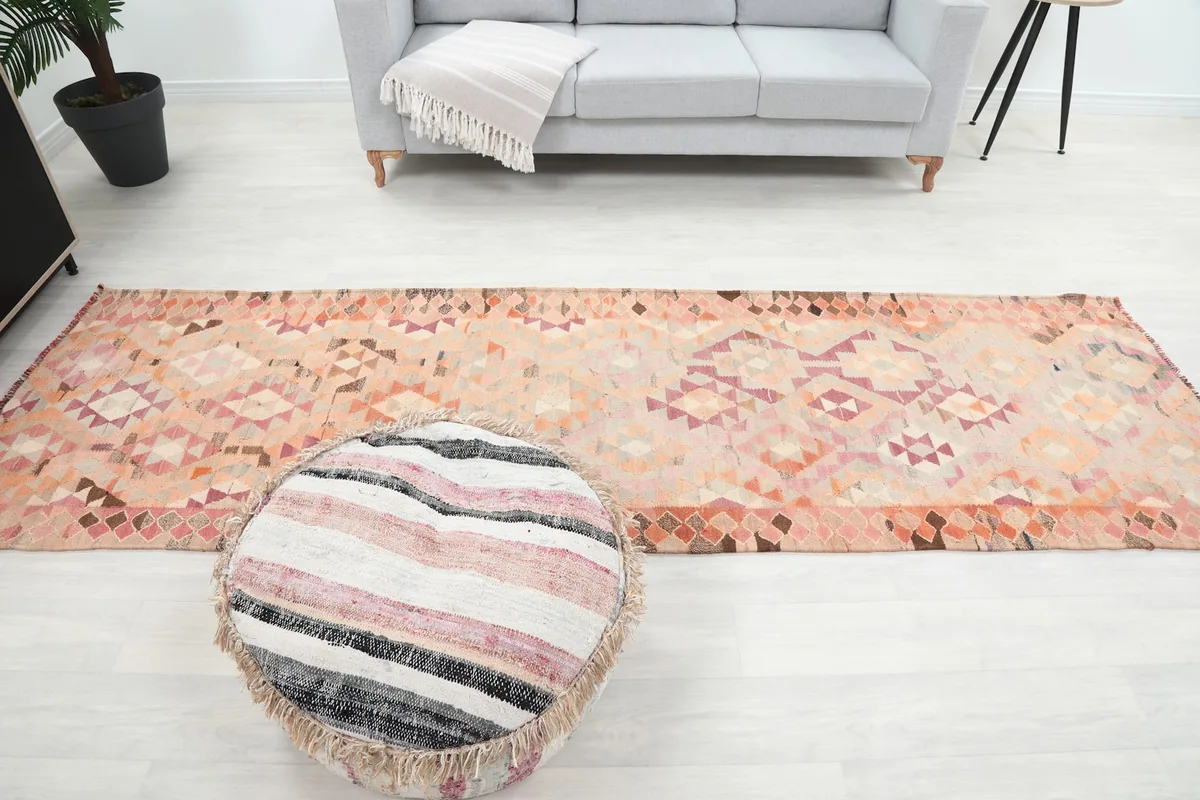 Full overhead view of the runner in the room, demonstrating its scale next to a sofa and pouf.