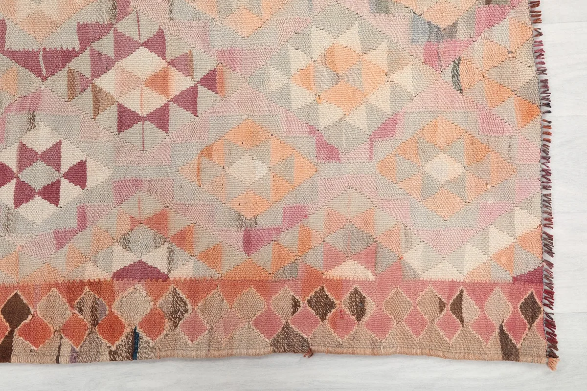 Detailed view of the rug's border and main field, showcasing the hand-knotted wool pile and tribal motifs.