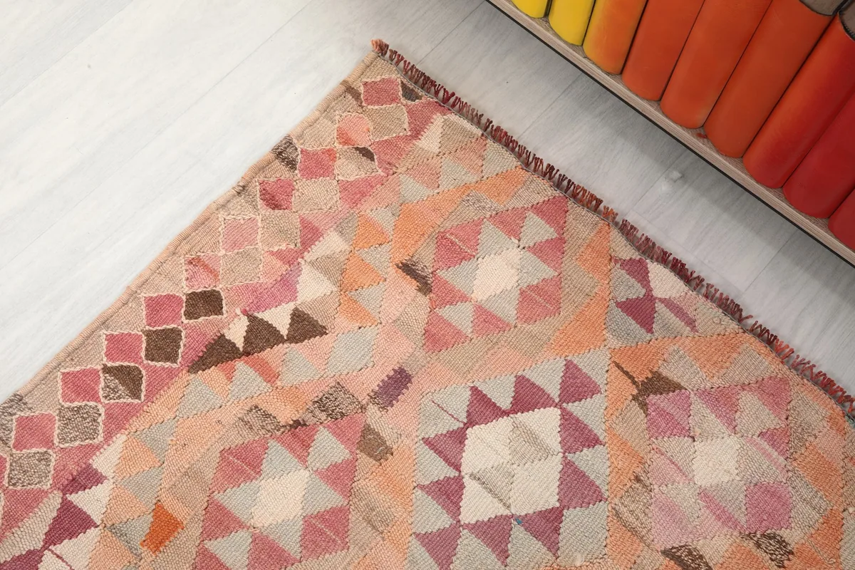 Corner detail of the runner, emphasizing the intricate geometric design and the blend of rose, rust, and beige tones.