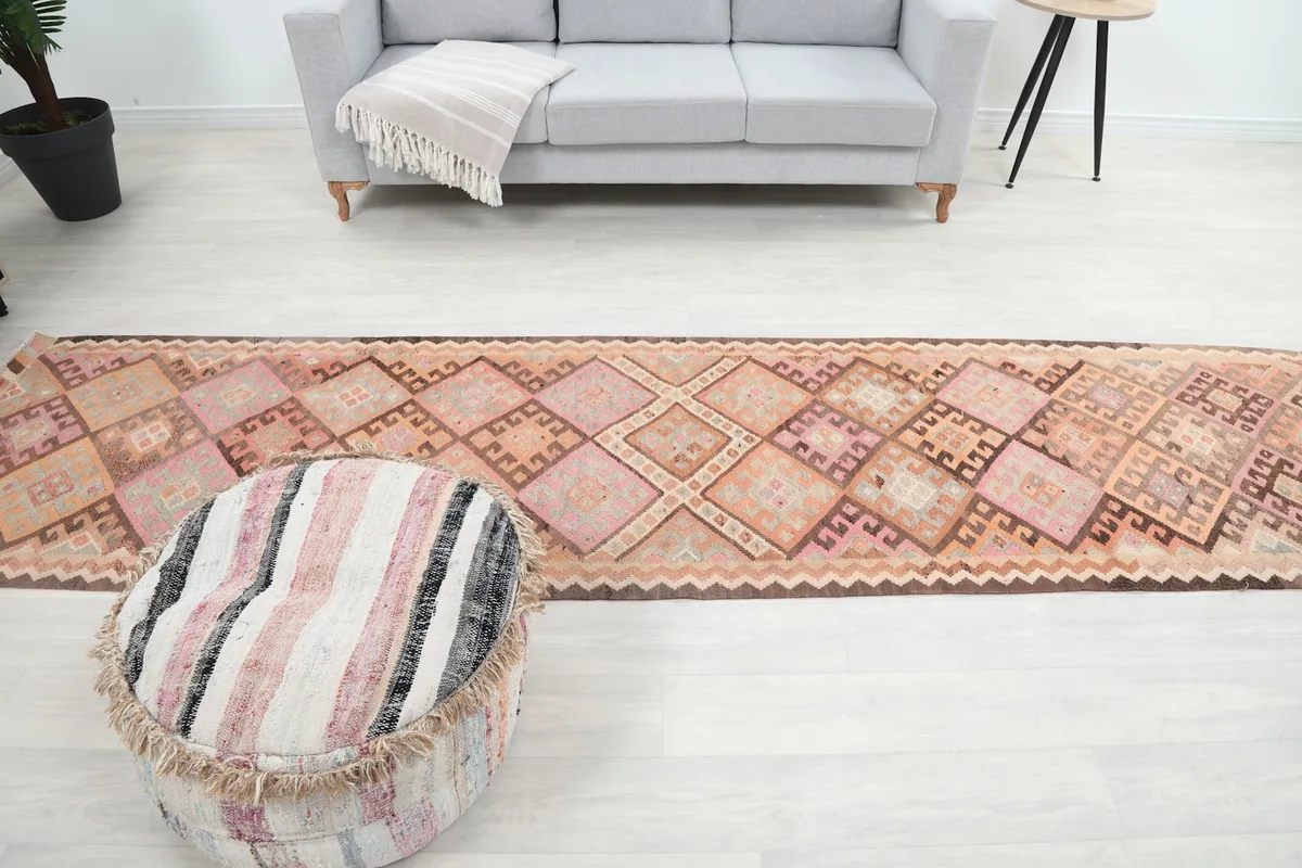 Wide shot of the runner rug in a room, showing its full length and vibrant colors against a light floor.
