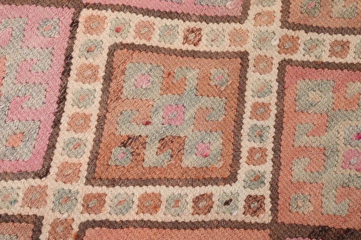 Close-up of the rug's texture and individual knots, showcasing the subtle color variations in the wool pile.