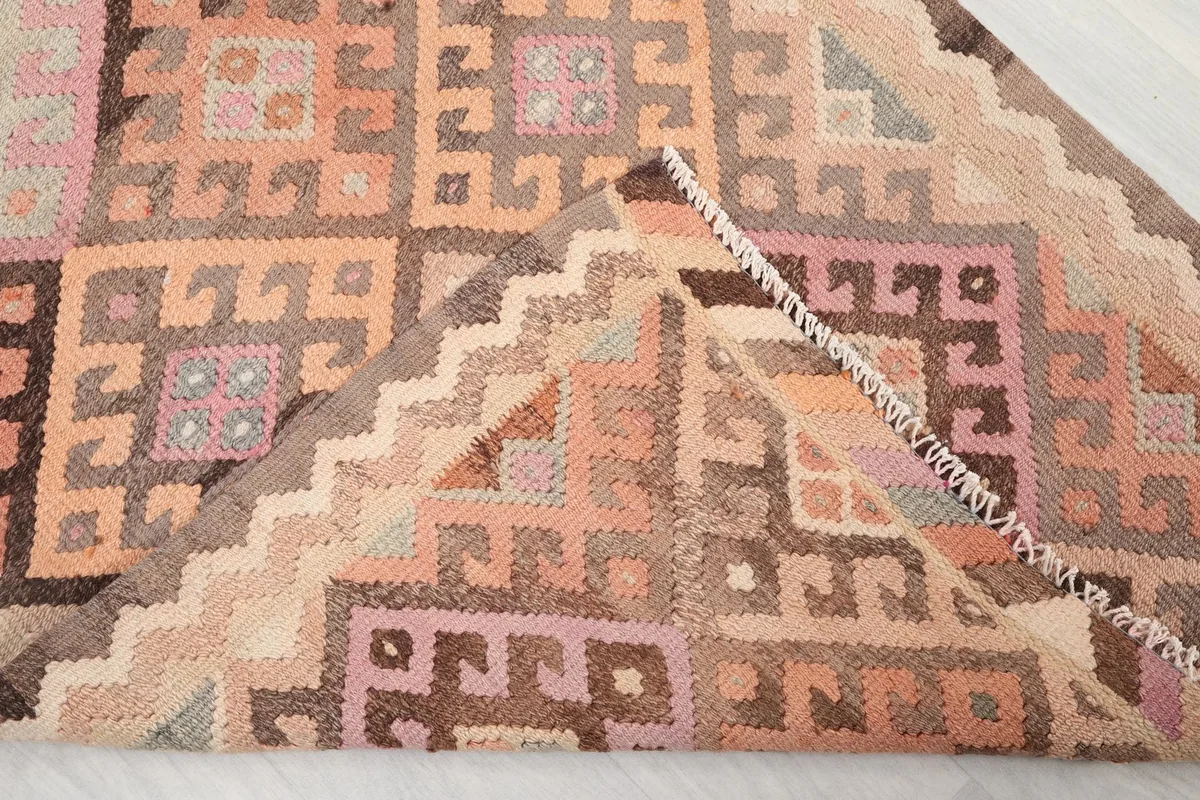 View of the back of the runner rug, showing the hand-knotted foundation and the neat finish.