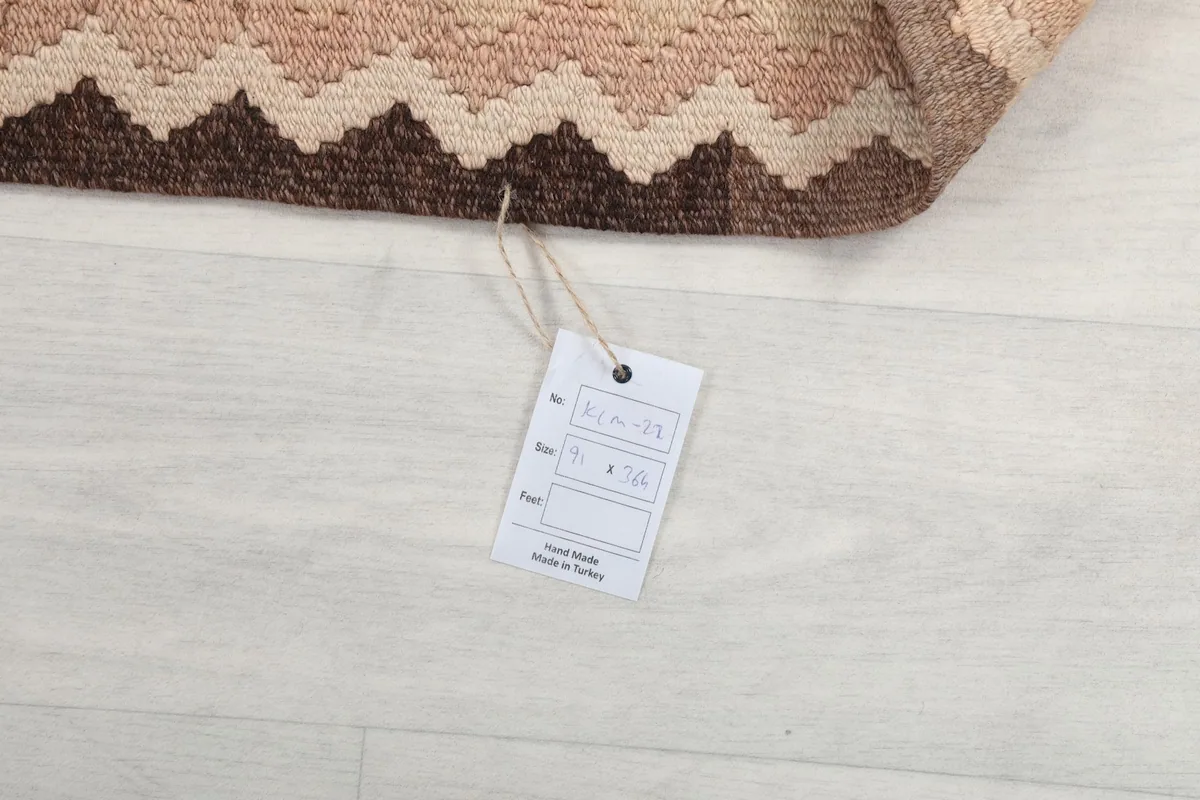 Product tag attached to the runner rug, confirming its hand-knotted origin and material details.