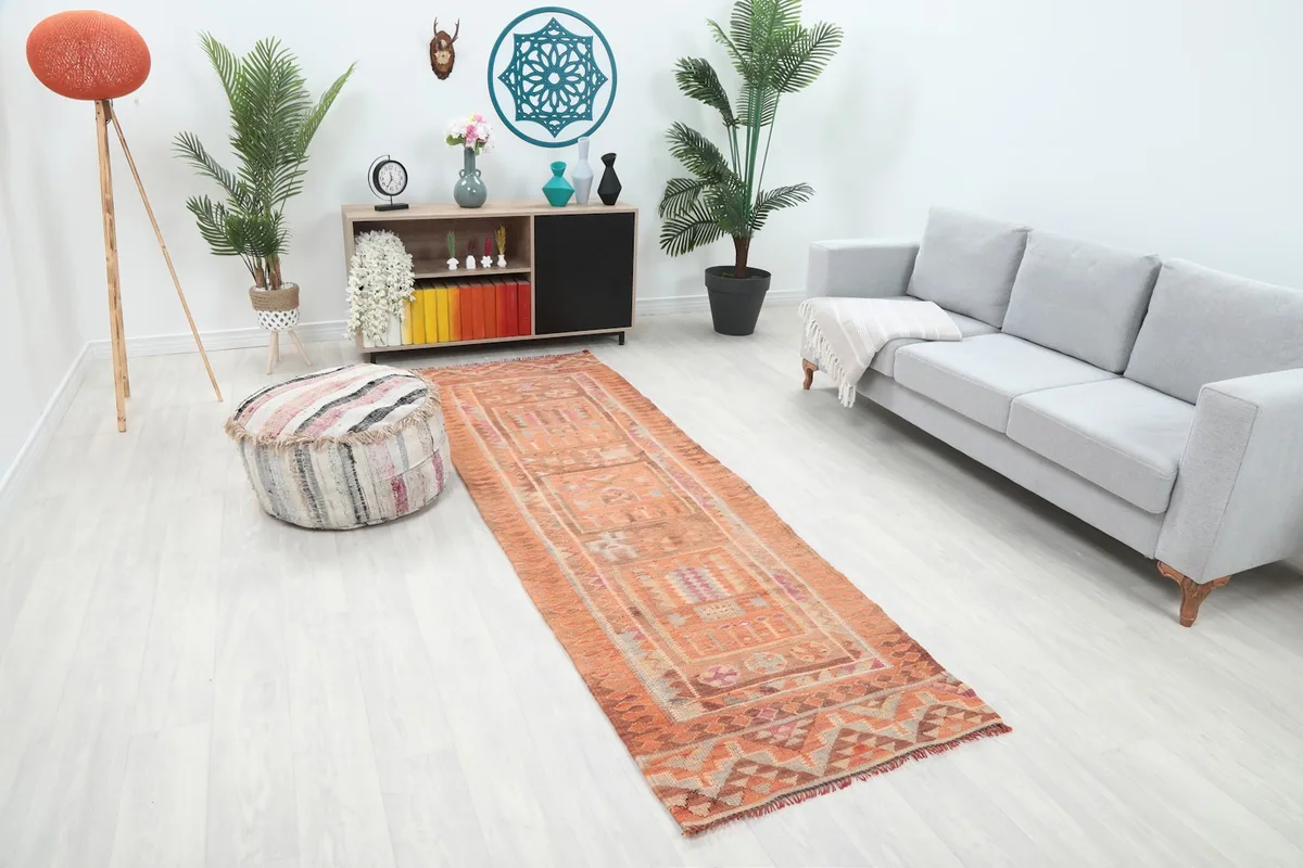Angle view of the hand-knotted Anatolian runner rug with its distinctive orange and brown tones in a living space.