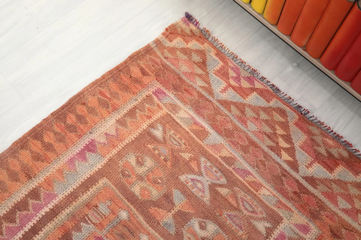 Corner detail of the runner rug, displaying the varied geometric patterns and color transitions in the border.