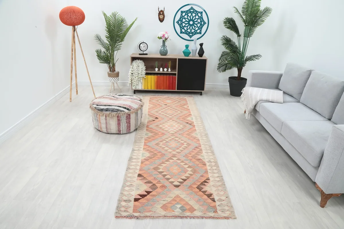 Runner rug in a modern living room setting with a light gray sofa and plants, showing its full length