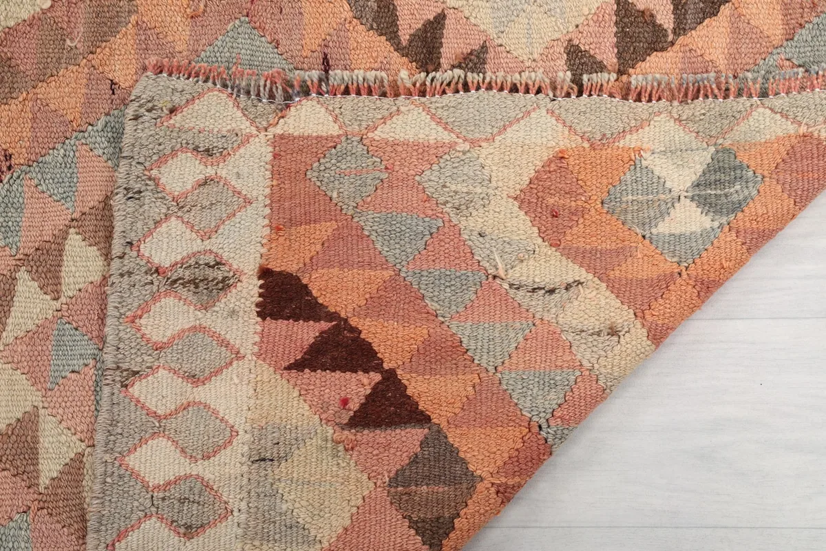 Close-up of the rug's edge, showing the pile, foundation, and the short, flat woven fringe