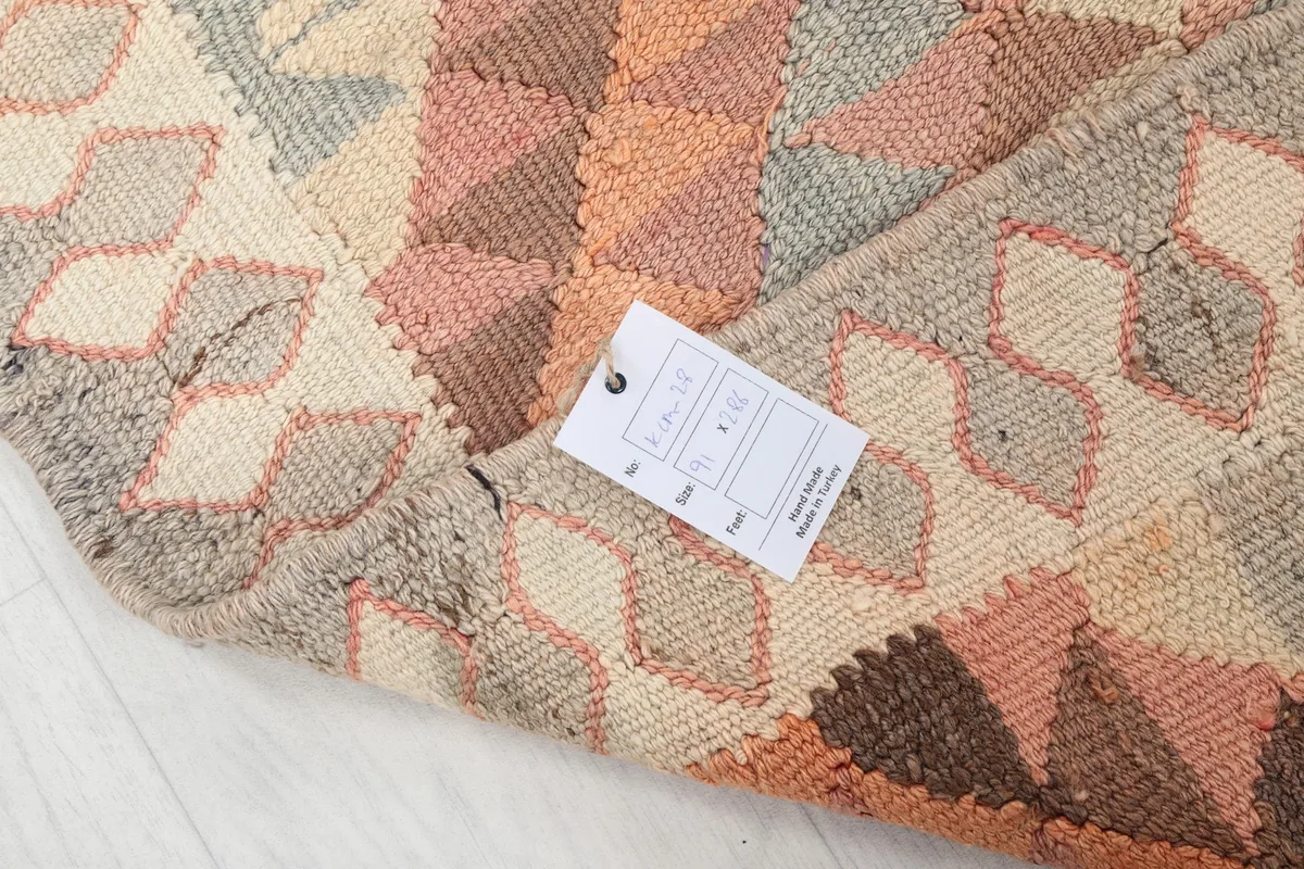 View of the rug's corner with the product tag, showing the intricate weaving and color tones