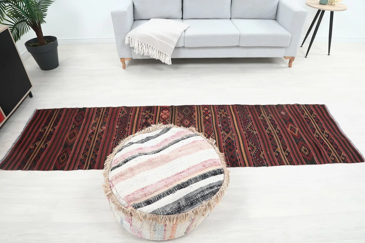 Overhead perspective of the runner rug in a room, with a sofa and ottoman