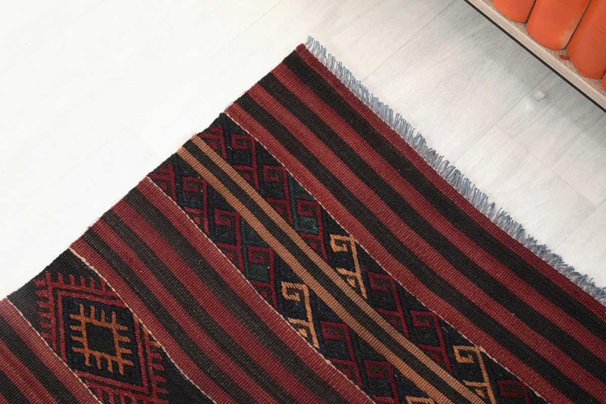 Detail of the rug's edge, showcasing the woven structure and the end fringe