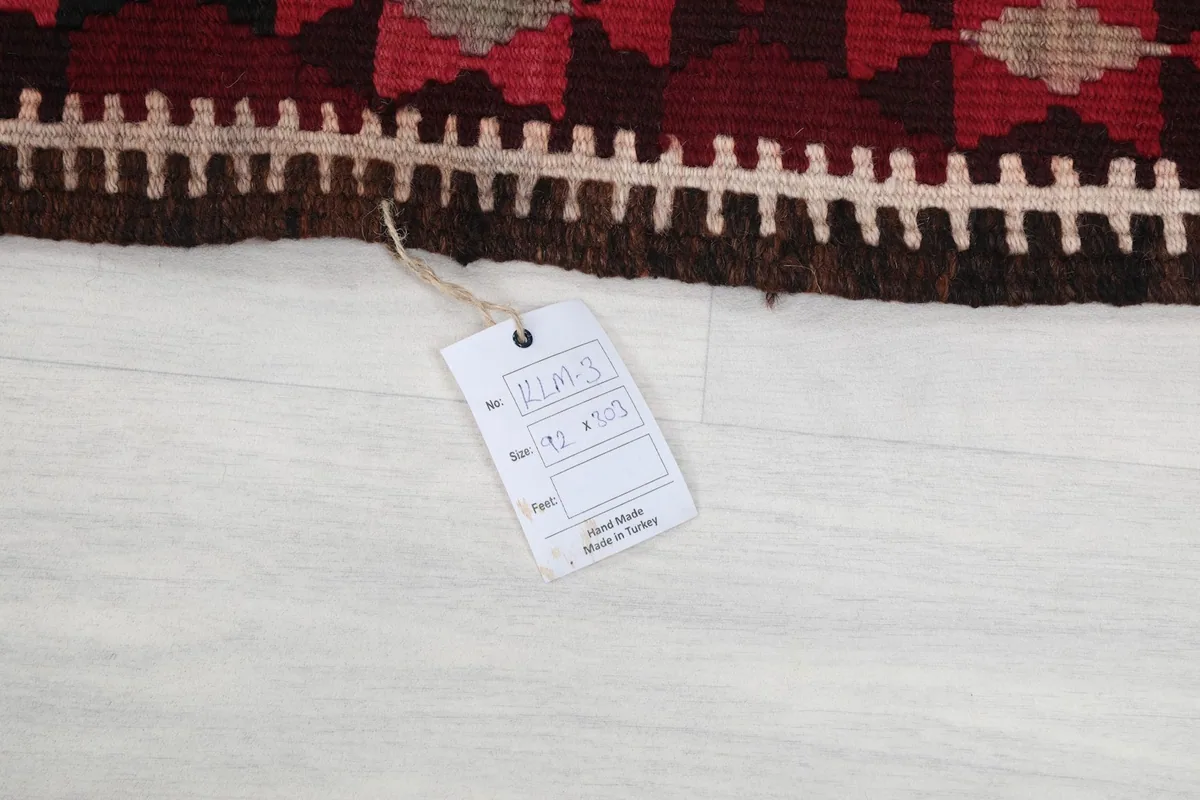 Tag showing the rug's dimensions and origin, attached to the corner of the runner.