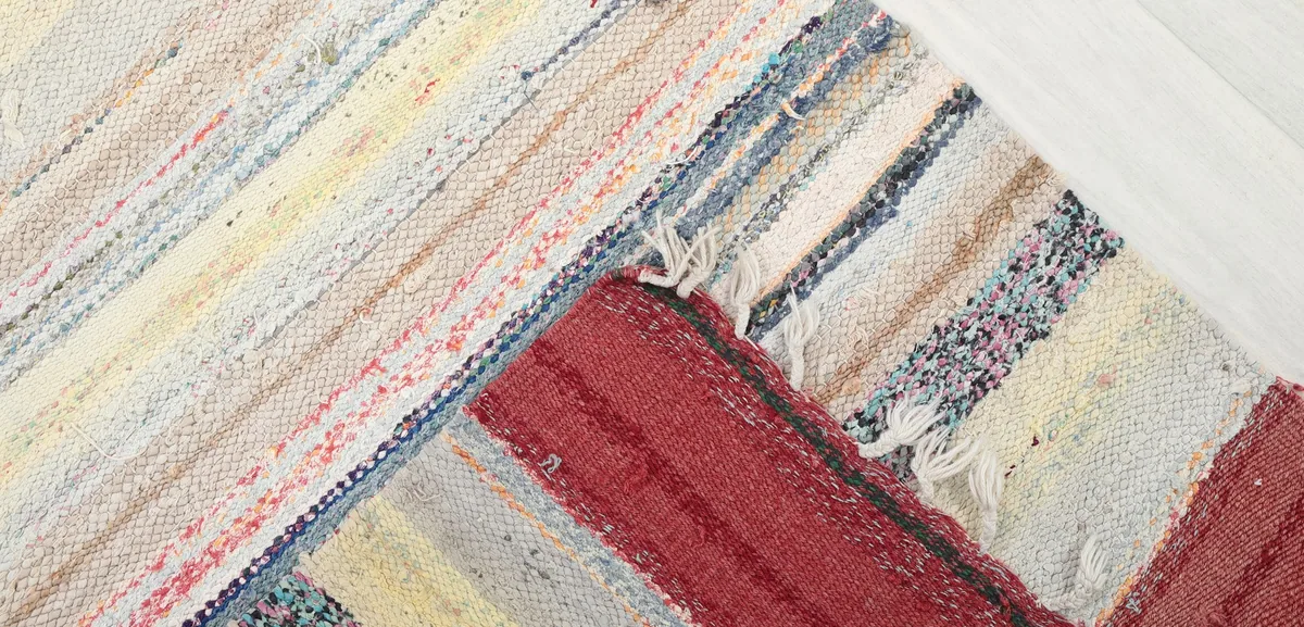 Corner of the rug folded back to reveal the hand-knotted construction and cotton foundation.