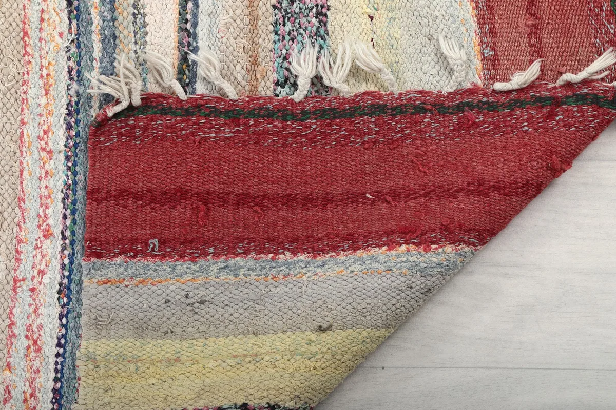 Close-up of the back of the rug, showing the reverse side of the hand-knotted wool pile and fringe.