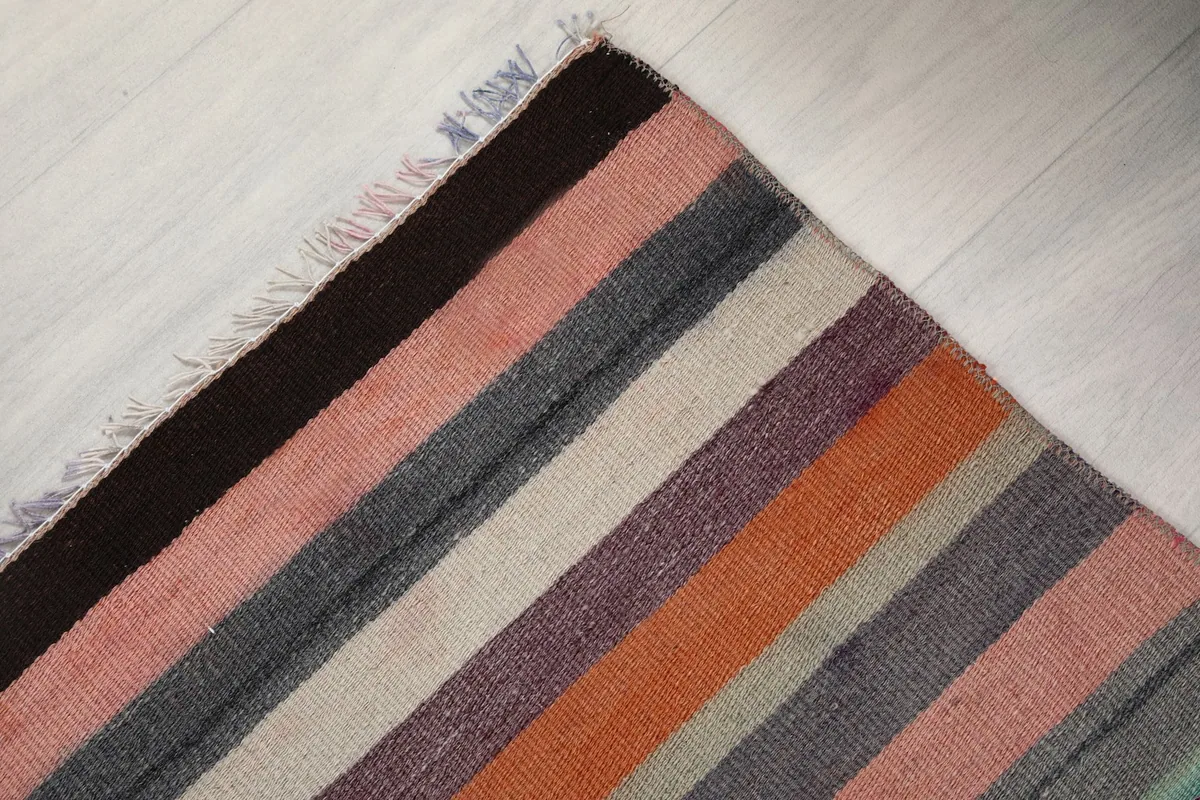 Corner view of the rug, showing the hand-knotted texture and short fringe