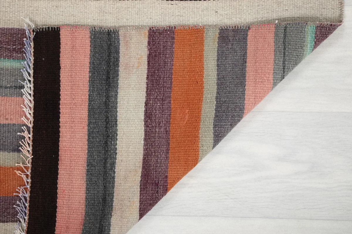 Close-up of the rug's reverse side and a corner, showing the tight knotting