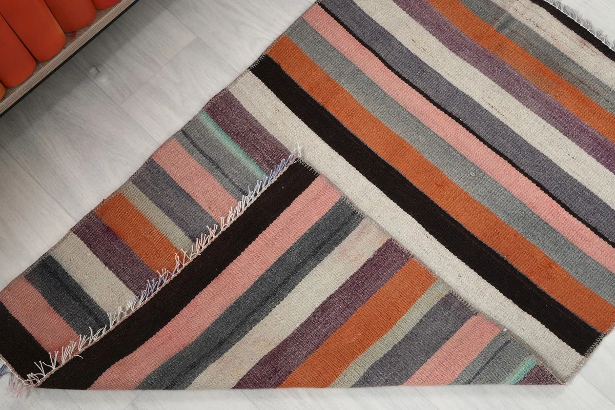 Rug folded back to reveal the cotton foundation and reverse side of the hand-knotted wool