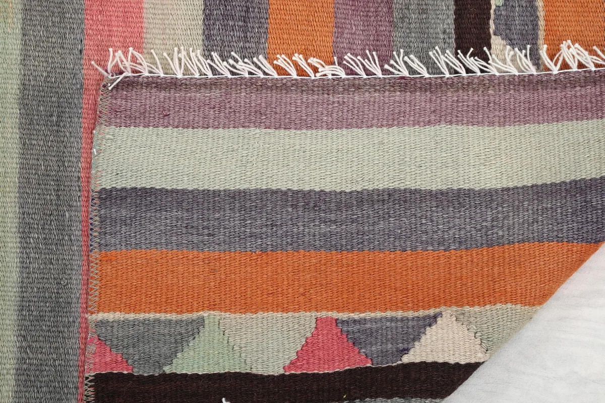 Close-up of the runner's fringe and the tightly woven edge, revealing the wool and cotton construction.