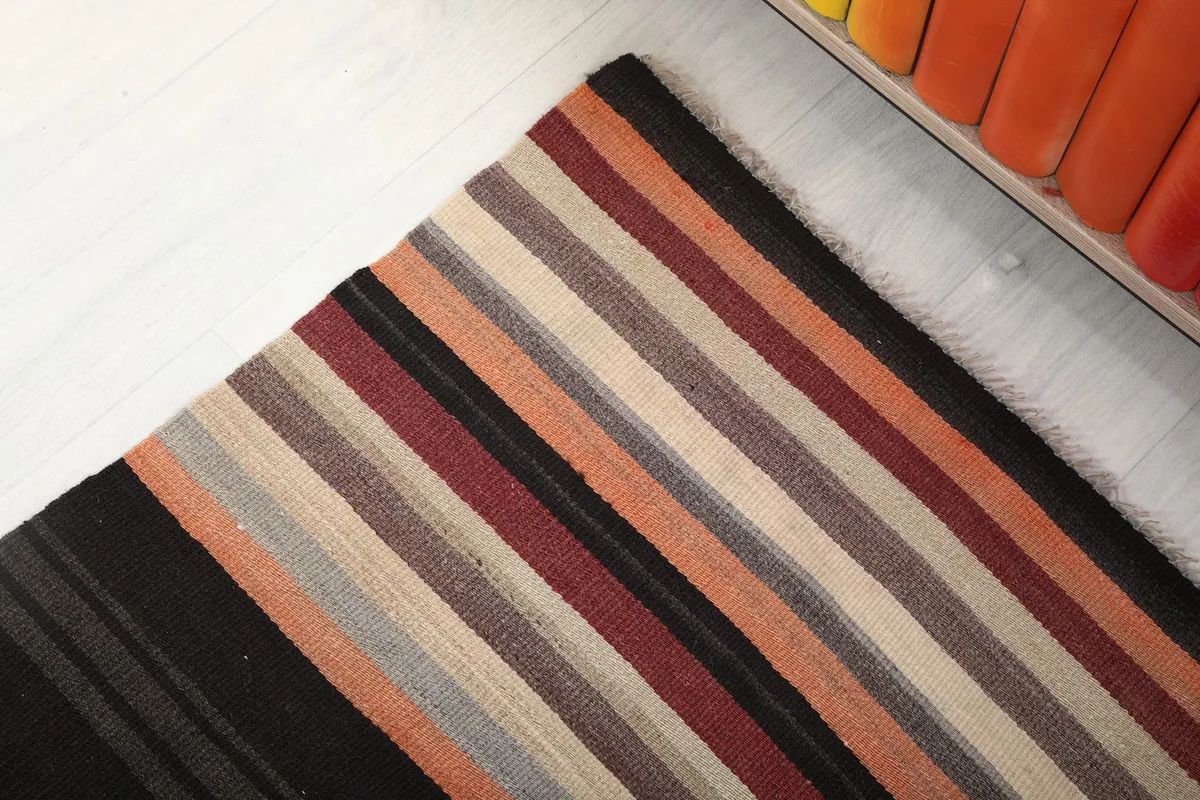 Angled view of one end of the runner rug, showing the transition of stripe colors