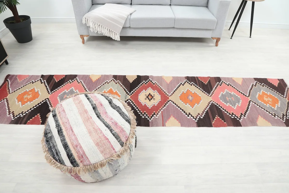 Full view of the runner in a room, positioned between a sofa and an ottoman, showcasing its scale
