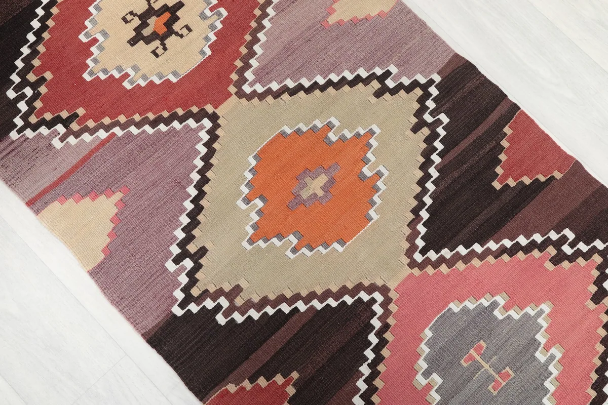 Close-up of the runner's design, highlighting orange and tan diamond motifs with zig-zag borders