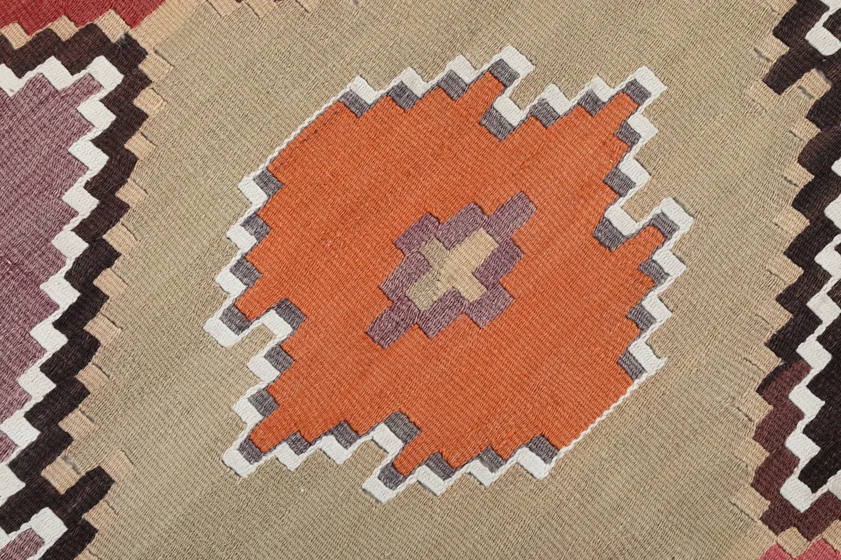Extreme close-up of an orange diamond motif with subtle details on the vintage wool pile