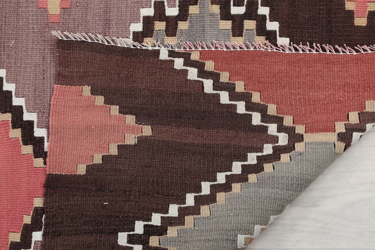 Another folded view, highlighting the texture of the wool pile and the intricate geometric weaving