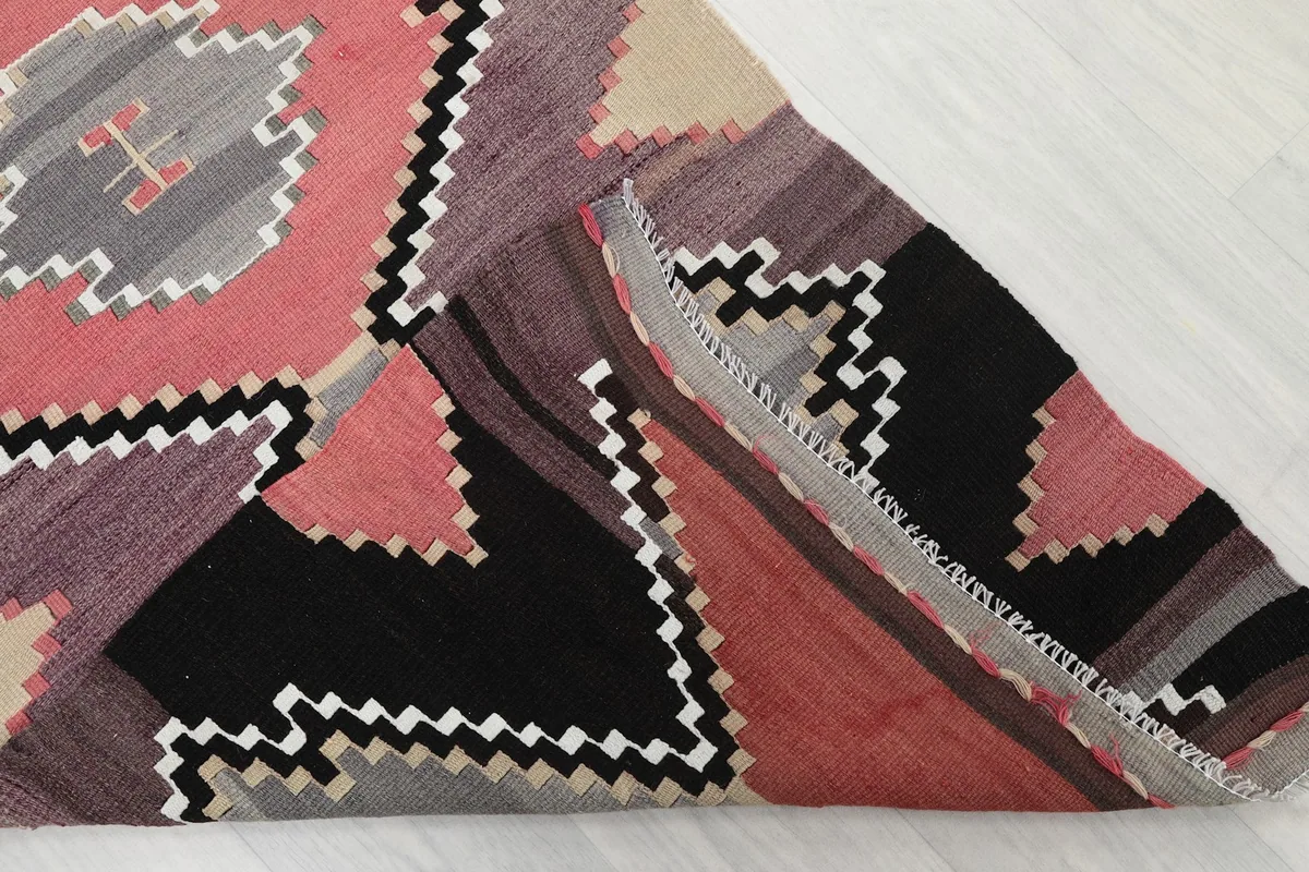 Folded edge of the rug revealing the wool pile and cotton foundation construction.