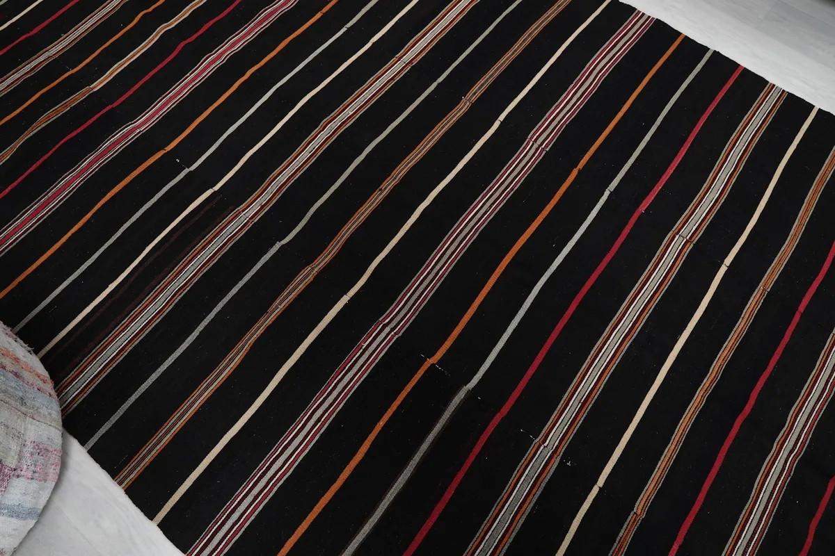 Diagonal view across the black striped rug highlighting the stripe pattern