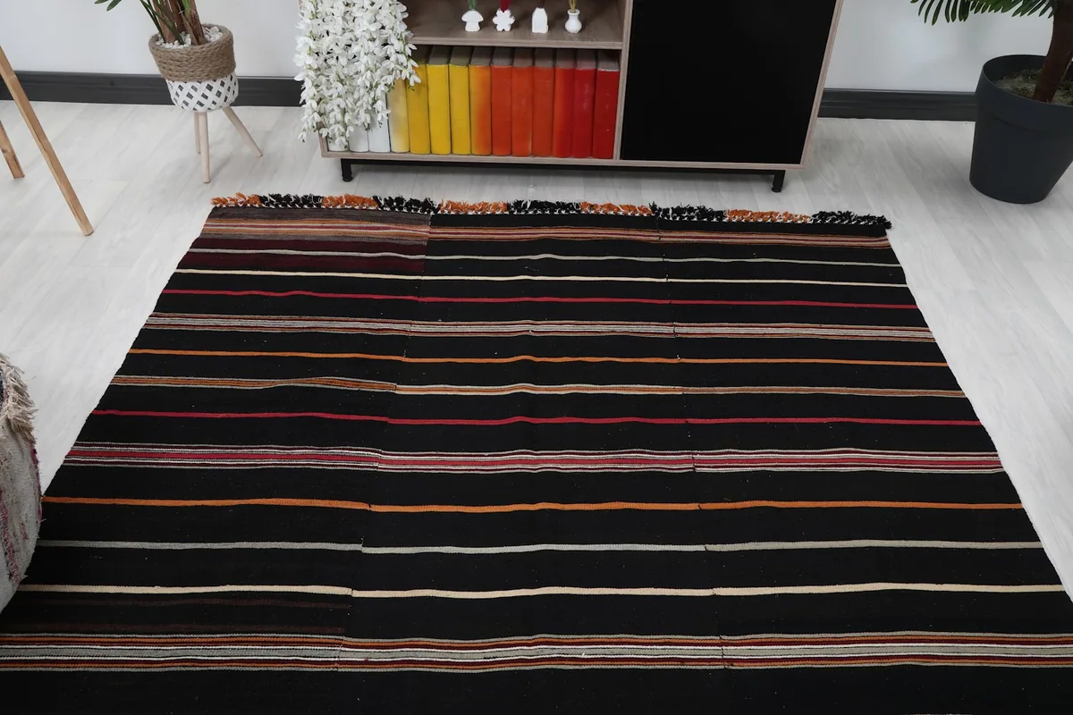 Overhead view of the black striped rug in a room, showing its full length