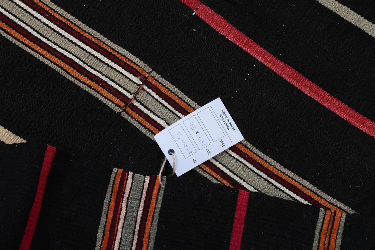 Detail of the rug's stripes with a size and information tag visible