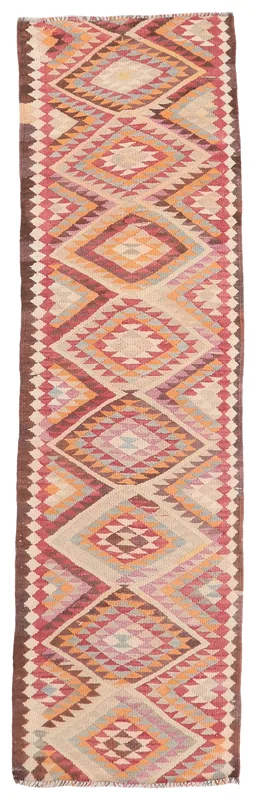 Full top view of the beige, red, and orange geometric runner rug on a white background